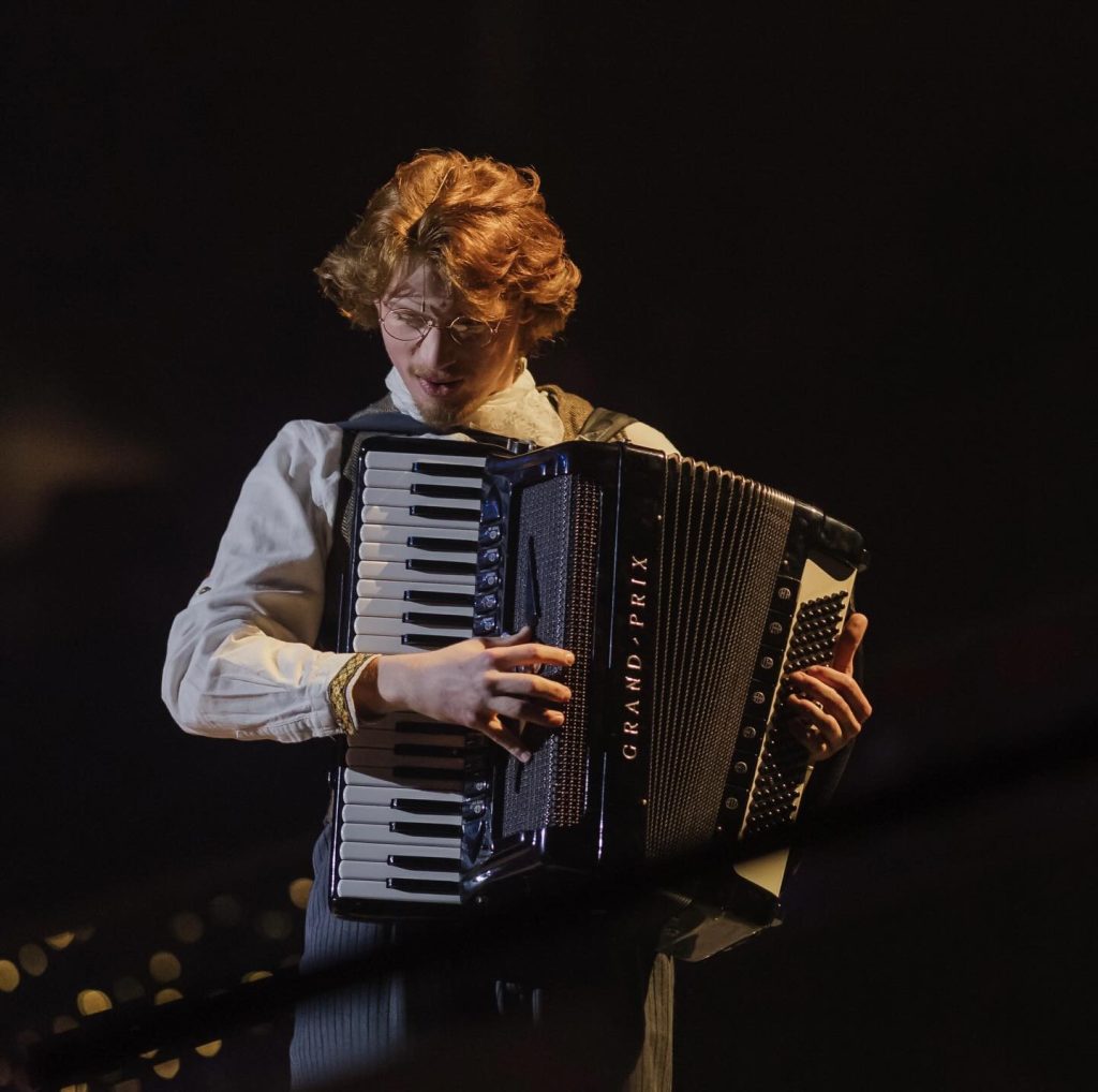 Charlie Abney on stage in costume playing accordion