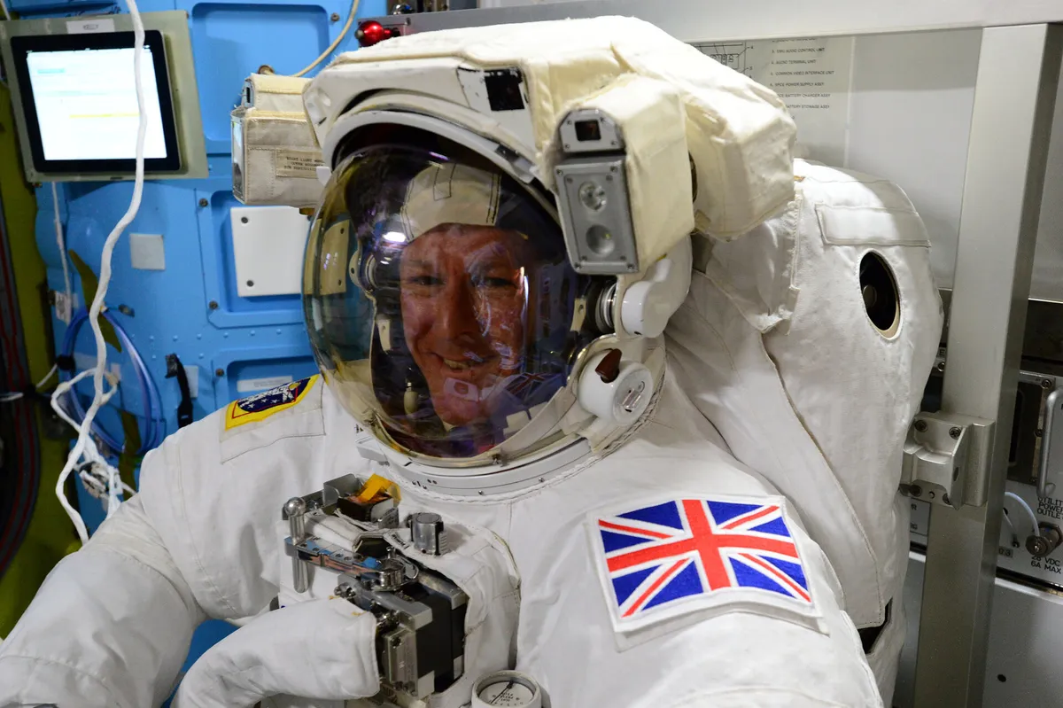 Tim Peake in EVA spacesuit, Union flag on his arm.