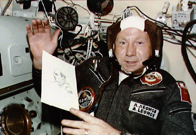 Cosmonaut Alexei Leonov displays drawing of Astronaut Thomas Stafford.