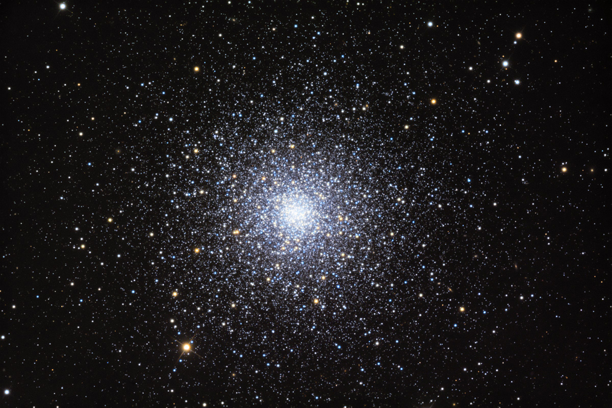 A dense cluster of stars shines brightly at the center of a dark sky, surrounded by numerous scattered stars.