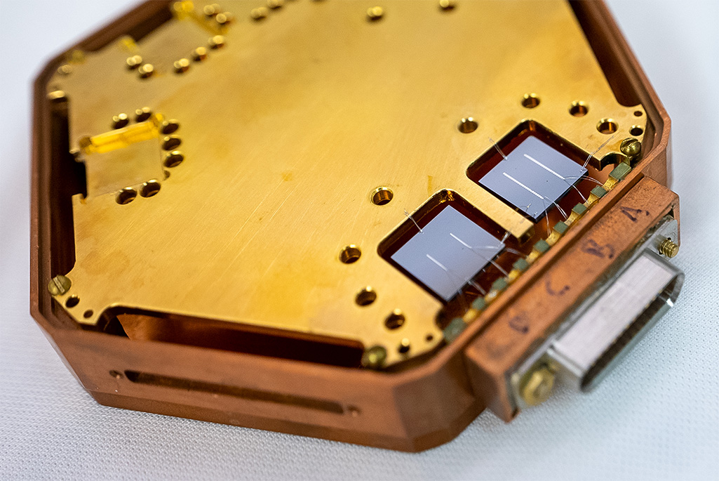 Close-up of a hexagonal structure holding two square chips, each with two reflective lines.