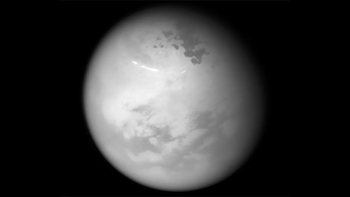 Methane clouds drift across Titan’s summer skies in this Cassini image. The darker patches are hydrocarbon lakes. Credit: NASA/JPL-Caltech/Space Science Institute