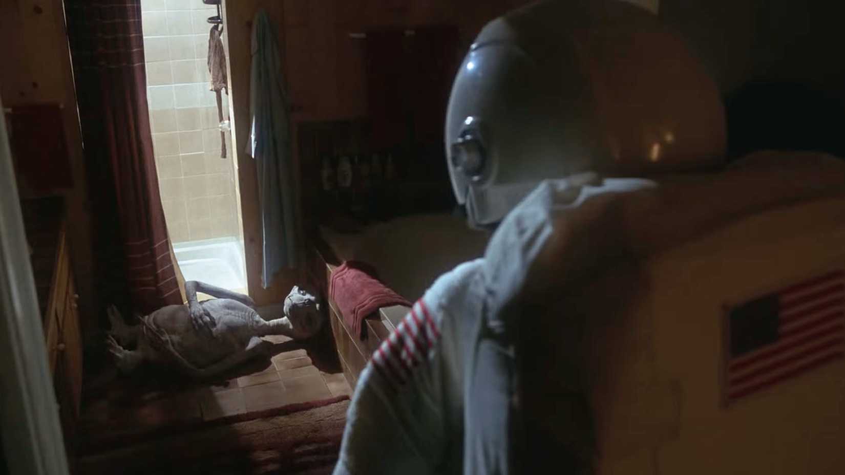 A man in an astronaut suit observes an ill E.T. in E.T. the Extra-Terrestrial