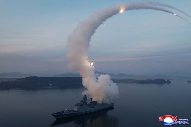 A cruise missile curves into the air, trailing a plume of smoke