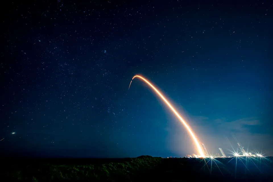 A bright light arching through a dark sky.