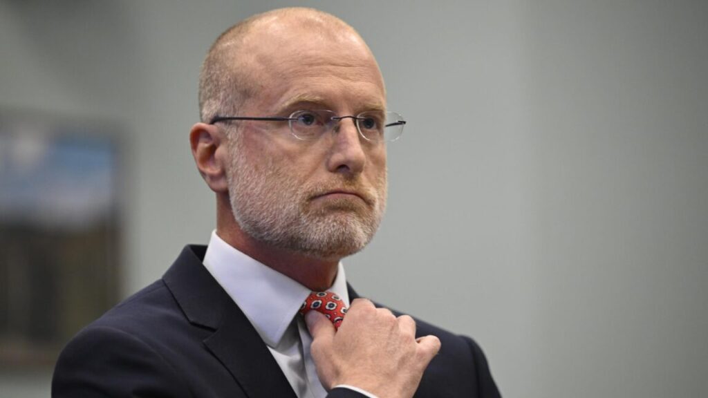 FCC Chairman Brendan Carr adjusts his tie at a Congressional hearing where he was testifying.