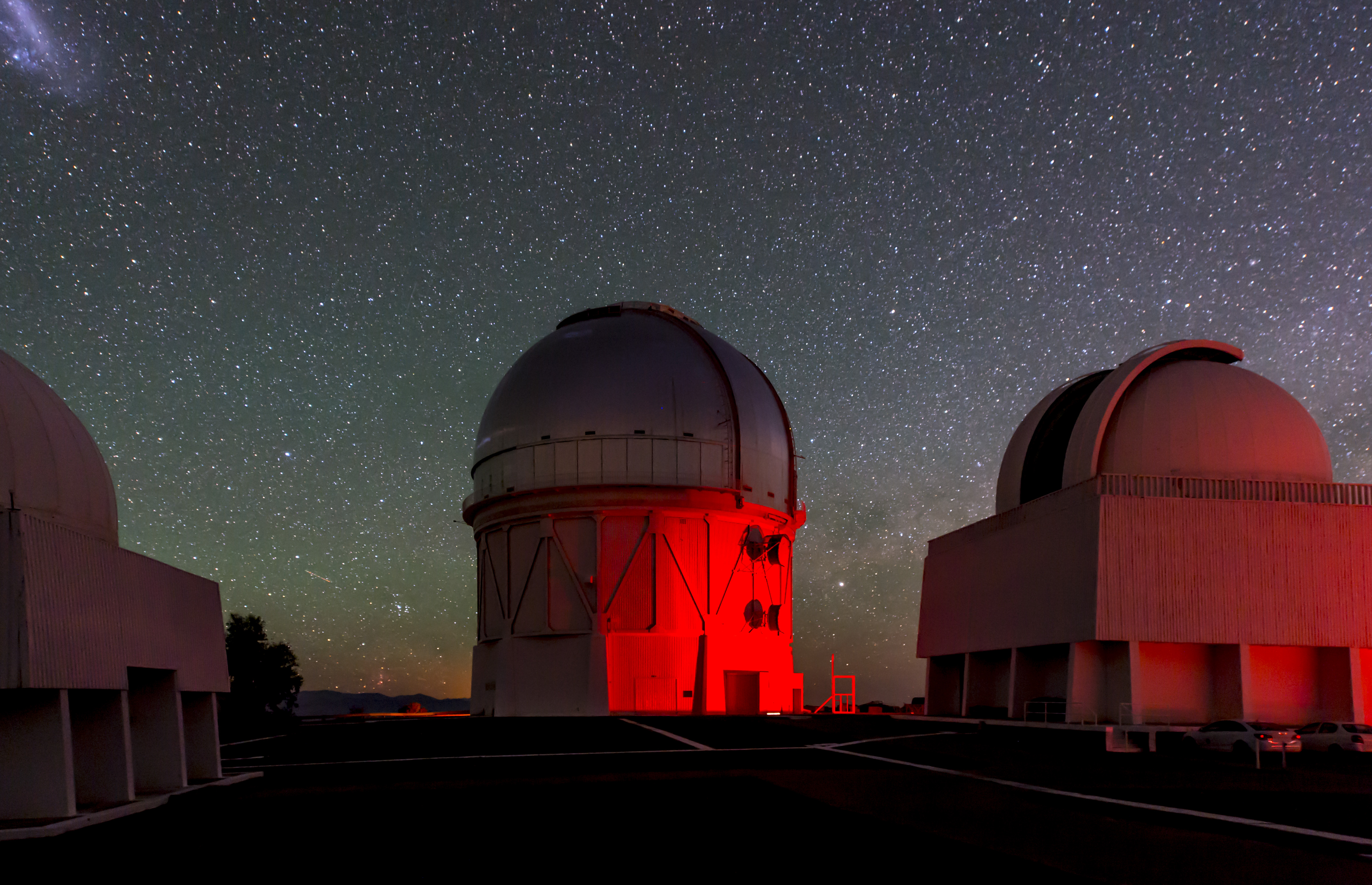 A dome washed in red light under the night sky.