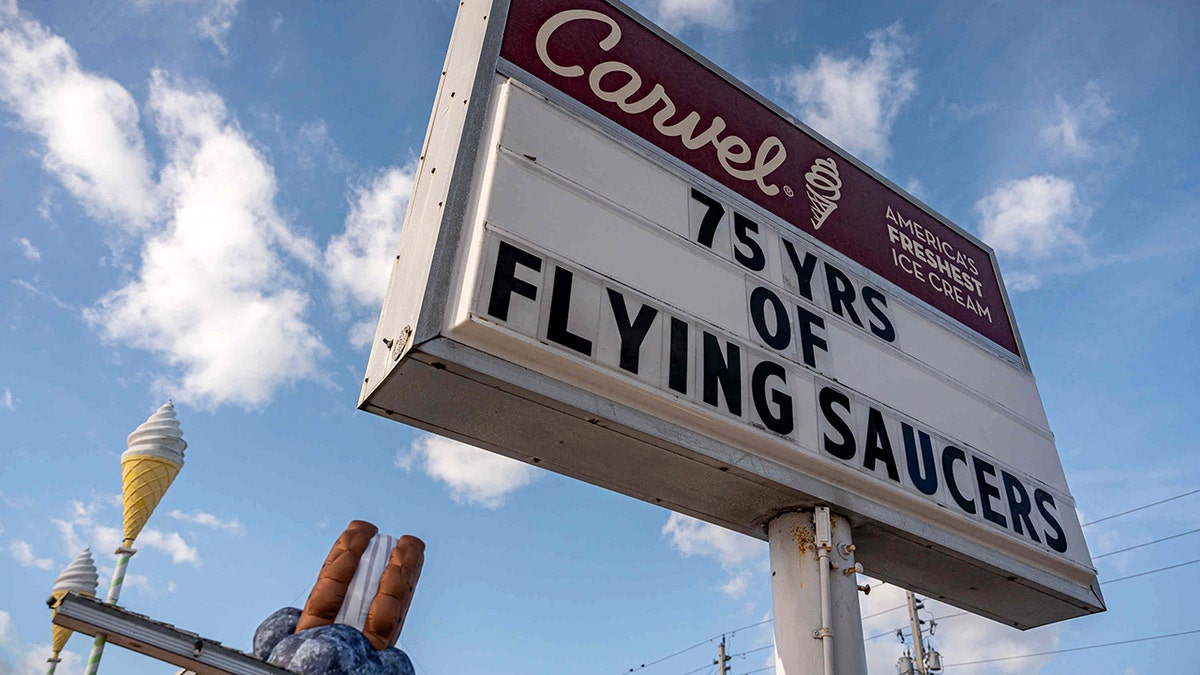 A sign reads "75 yrs of Flying Saucers," in front of a giant Flying Saucer inflatable, at the Carvel shop in West Palm Beach, Florida.
