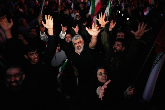 A large crowd gathered in mourning, with some people with their arms raised