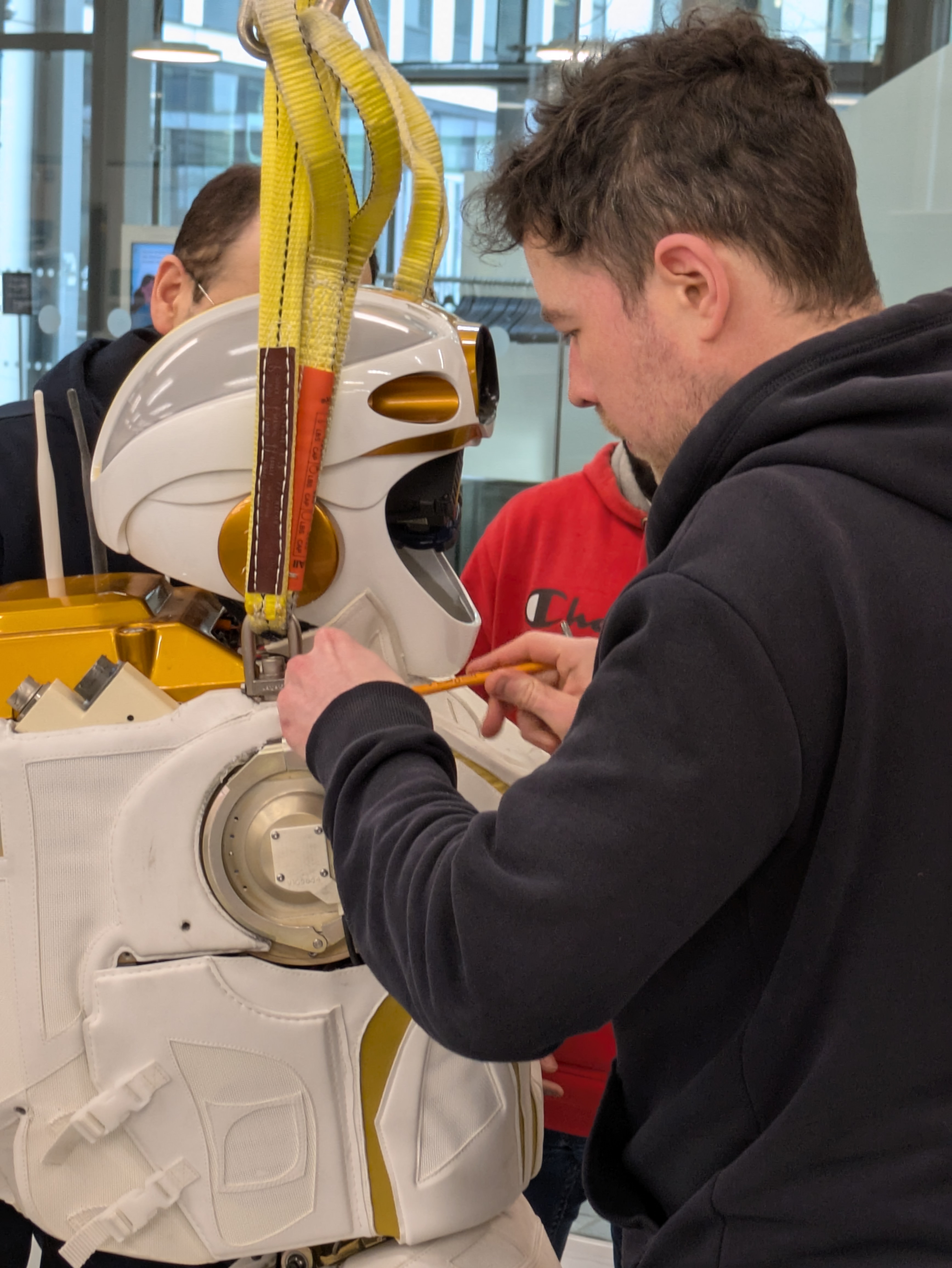 A man adjusts a setting on the side of the Valkyrie robot