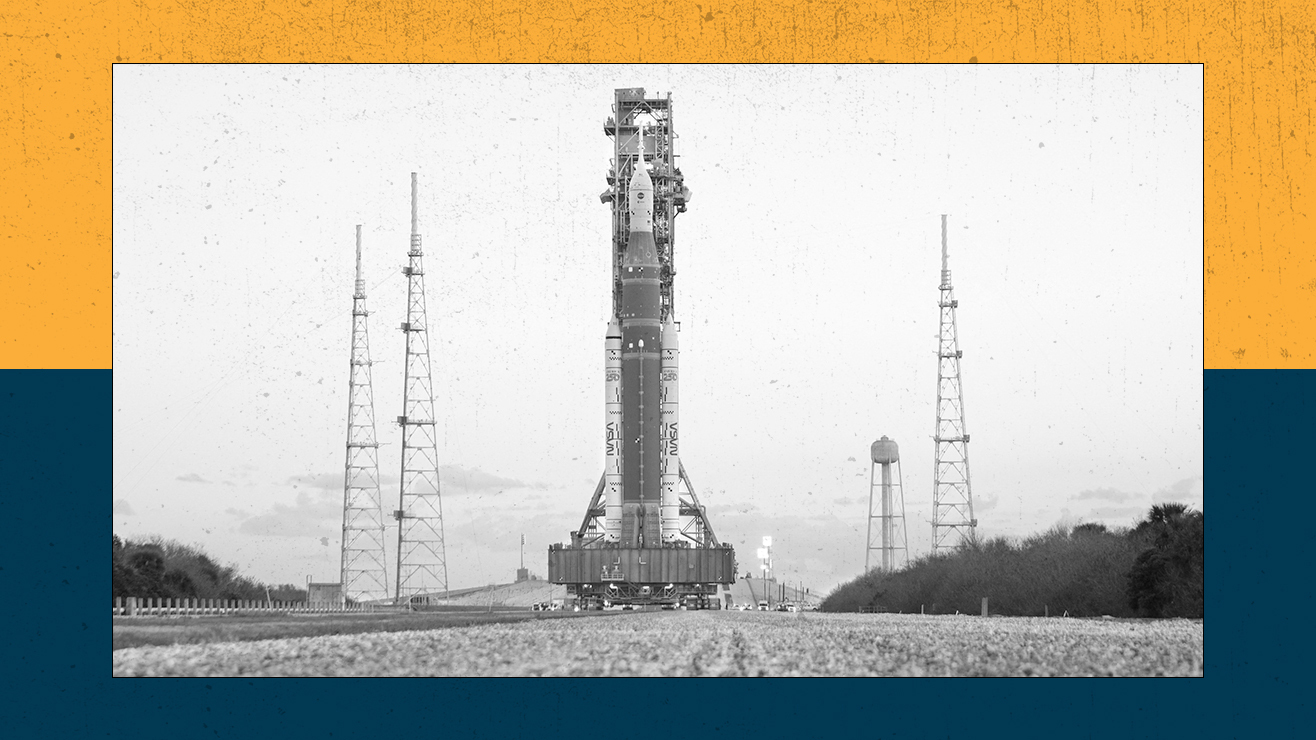 NASA's Artemis II rocket rolls along a gravel track.