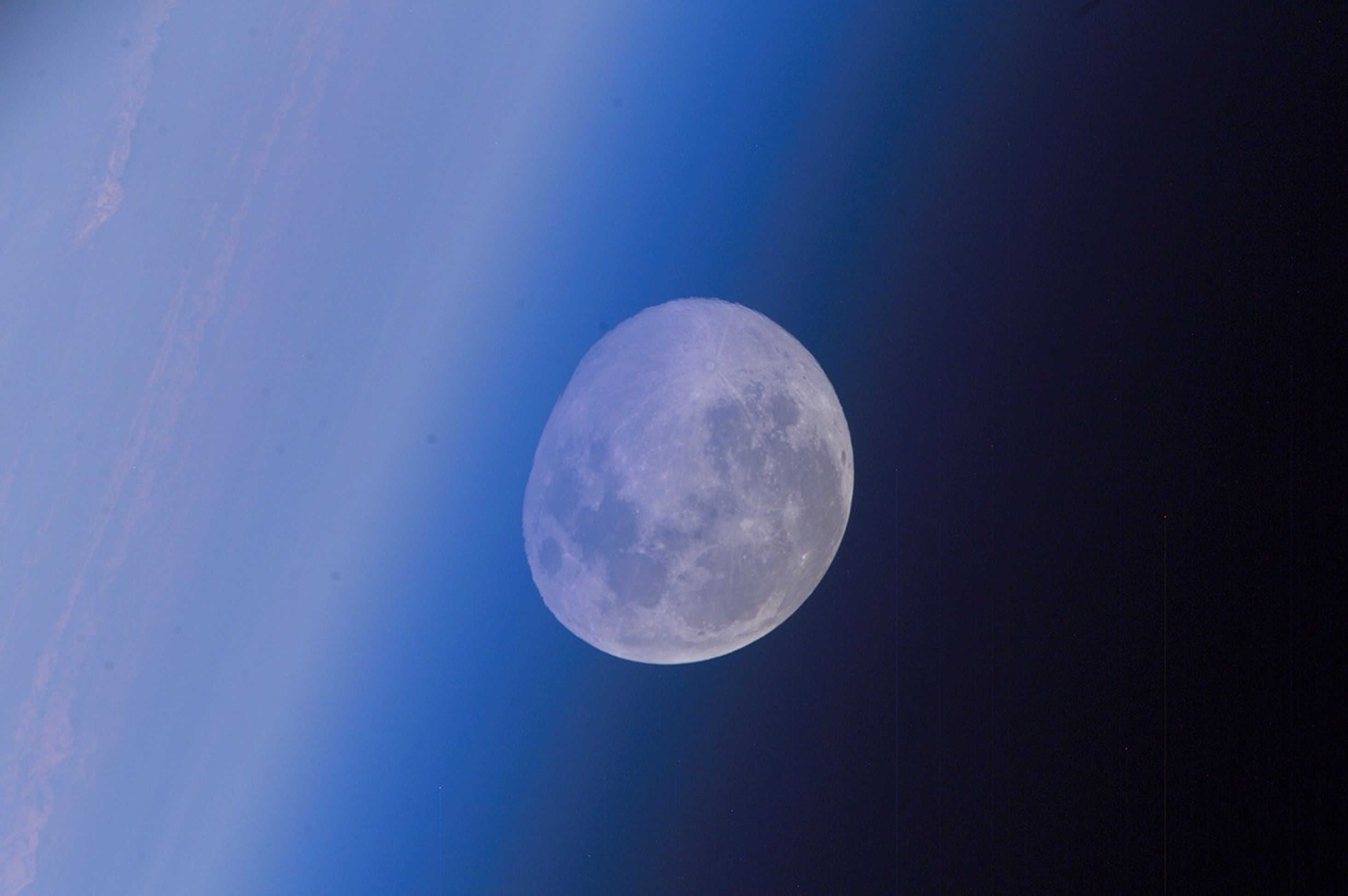 Moon at horizon seen through blue hazy atmosphere