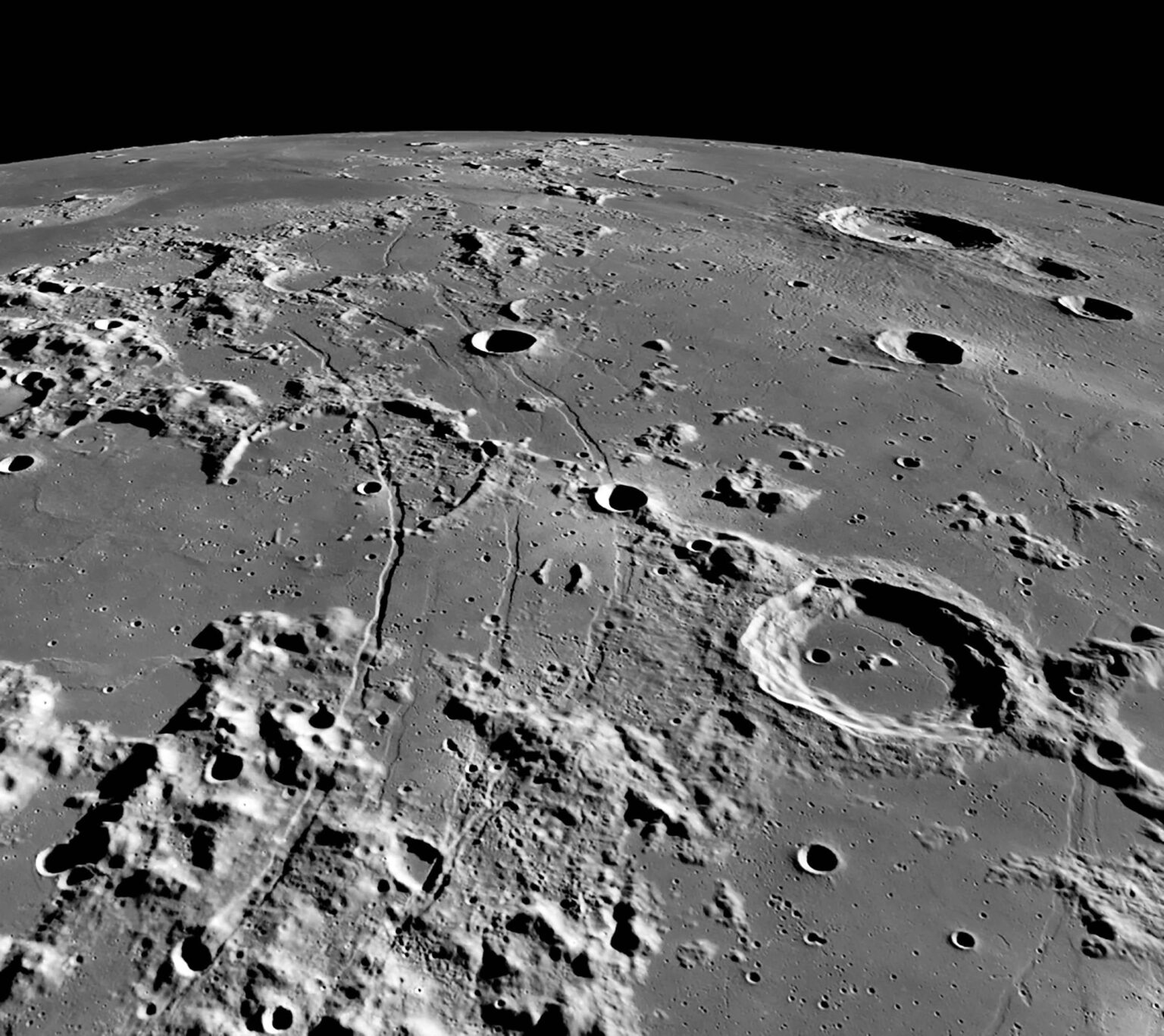 An oblique view of Rimae Hippalus on the Moon, showing the extent of the grabens, which span over 250 kilometers. The image width is roughly 150 kilometers at the bottom, and 500 kilometers on the horizon. The central peak crater Campanus (46-kilometer diameter) is in the right foreground. An oblique view of Rimae Hippalus on the Moon, showing the extent of the grabens, which span over 250 kilometers. The image width is roughly 150 kilometers at the bottom, and 500 kilometers on the horizon. The central peak crater Campanus (46-kilometer diameter) is in the right foreground.