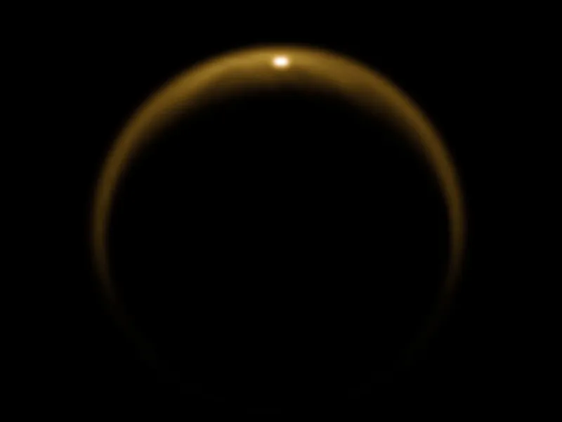 An image of Titan captured by the Cassini spacecraft on July 2009. The bright spot at the top of Titan’s disc is sunlight reflecting off the surface of a hydrocarbon lake. Dragonfly will explore these pools of liquid to search for conditions suitable for the development of life. Credit: NASA/JPL/University of Arizona/DLR