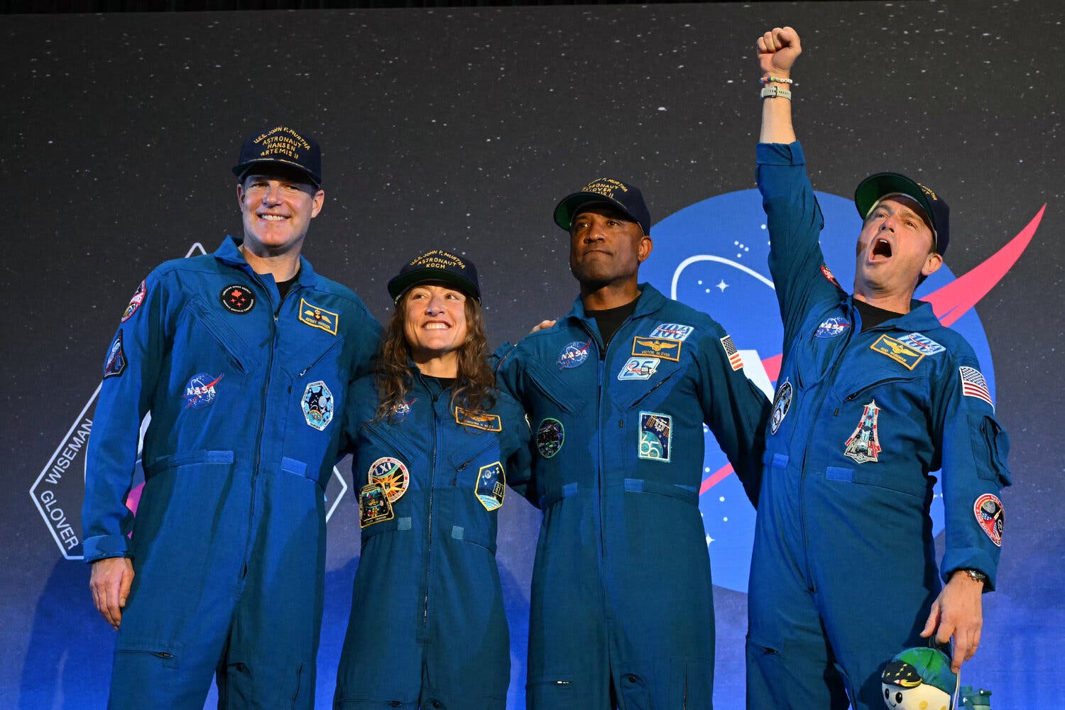 Four astronauts on a stage. 