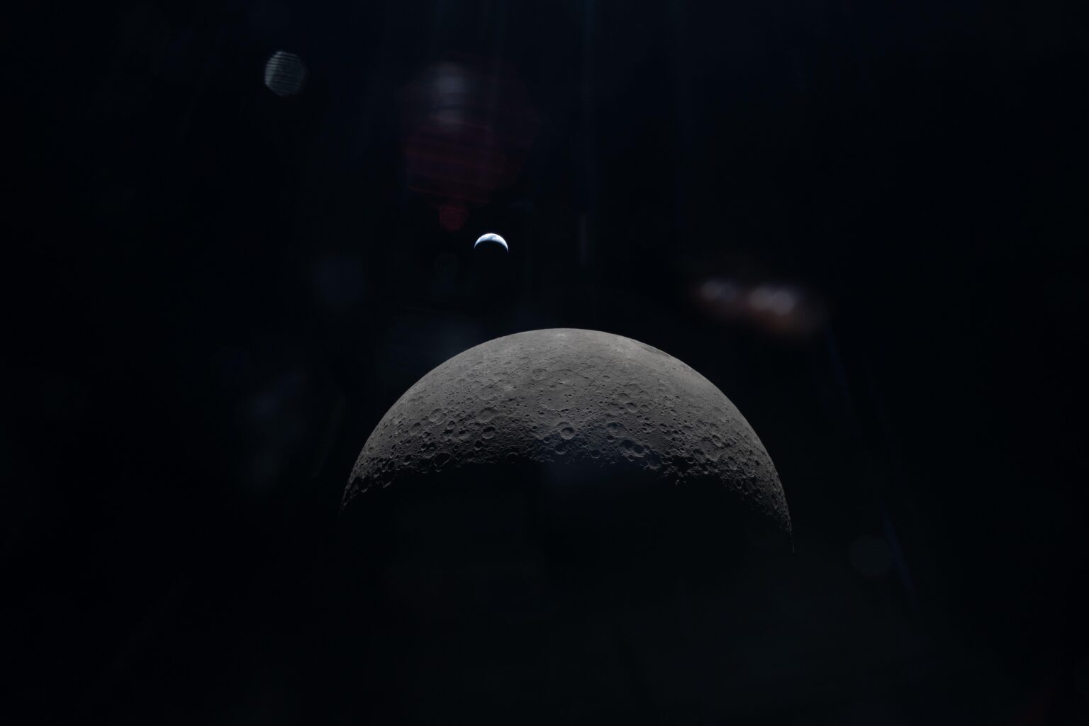 Distant view of a crescent Earth over the far side of the moon