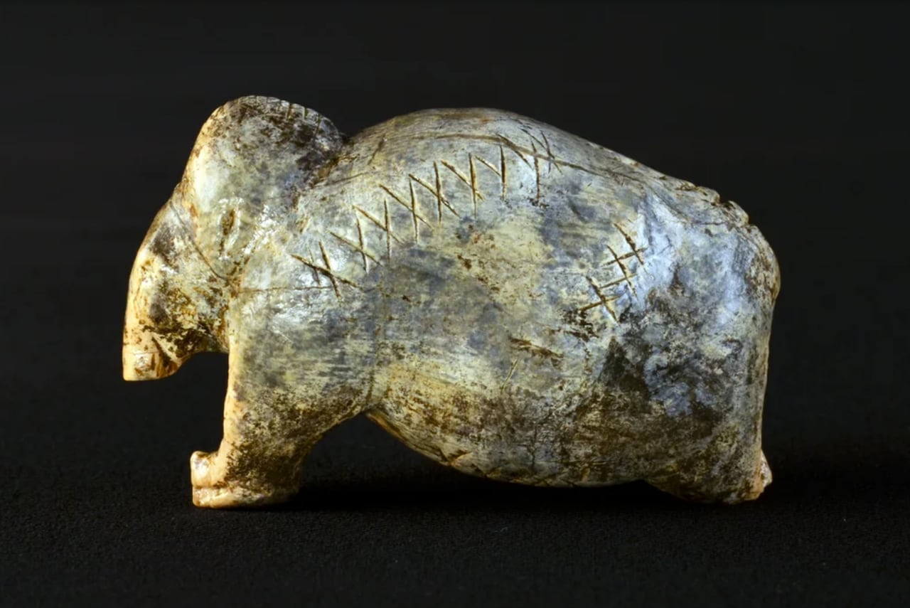 a hand-carved beige stone figurine of an elephant