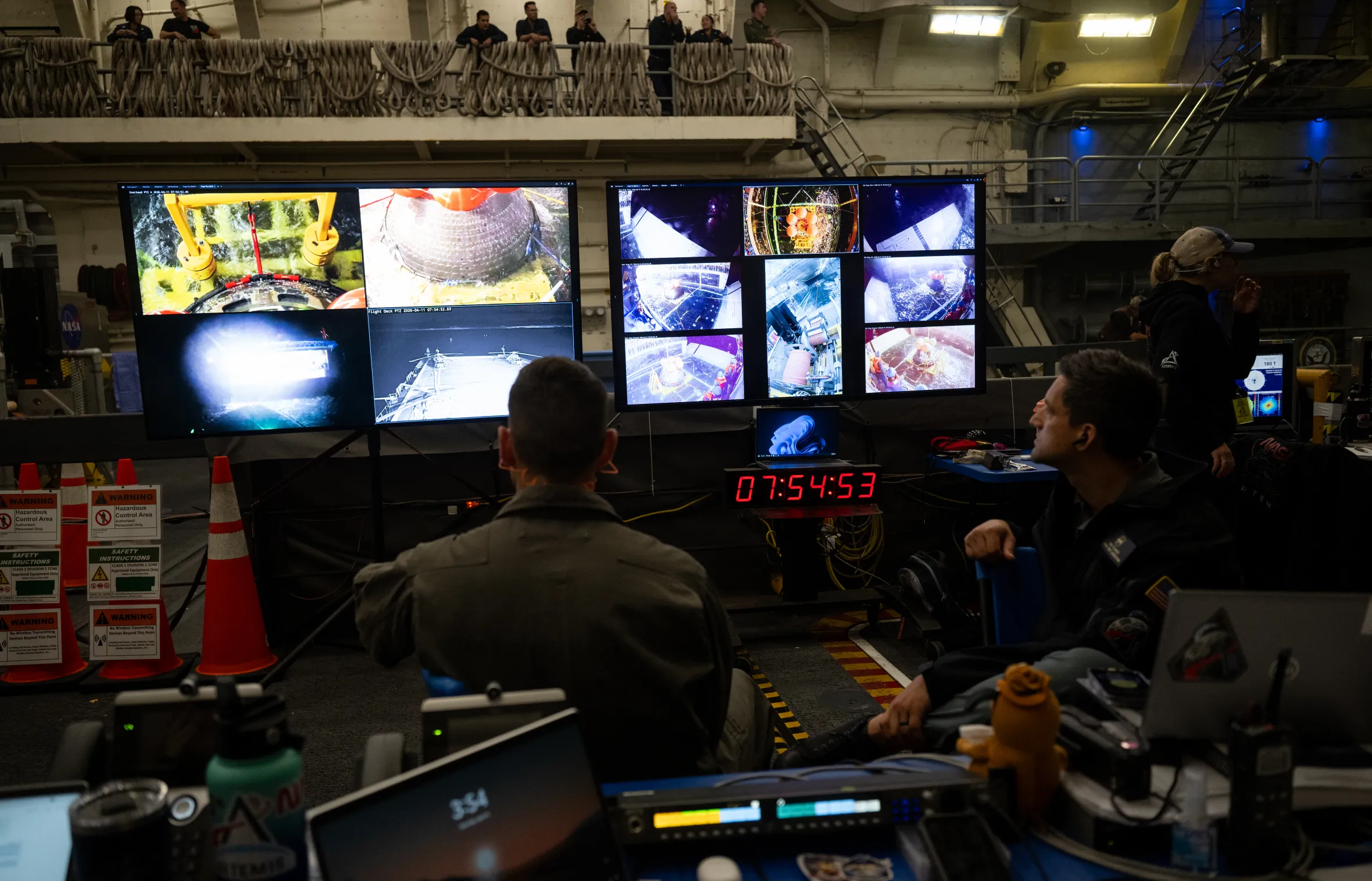 NASA’s Landing and Recovery team monitoring multiple screens showing views of the Orion spacecraft in the water.