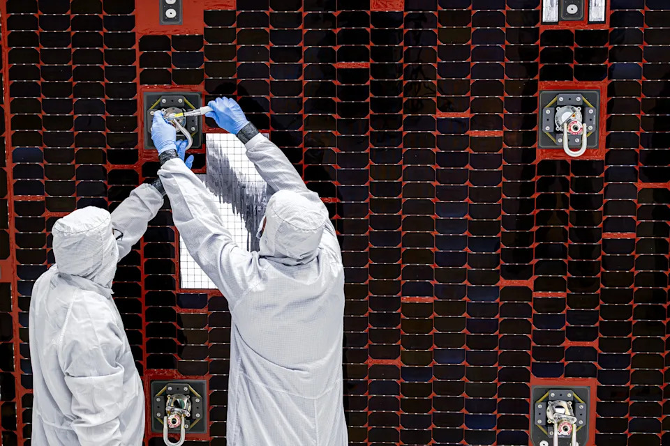 Technicians assemble the solar panels on the Nancy Grace Roman Space Telescope.