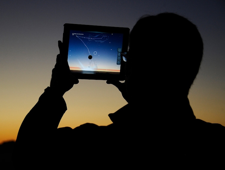 A man using an app on an iPad to line up the passing comet. (Photo: Reuters)
