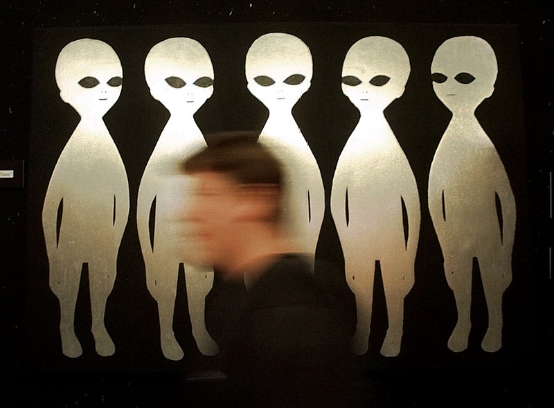 FILE - A patron passes a painting inside the International UFO Museum and Research Center in Roswell, N.M., on June 10, 1997.  (AP Photo/Eric Draper, File)