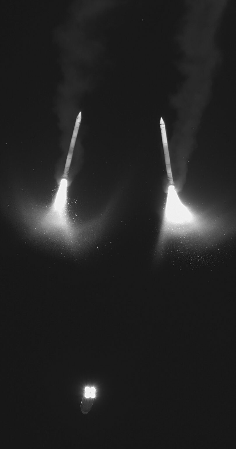 In this black and white infrared image, two solid rocket boosters separate from the core stage during Artemis II ascent