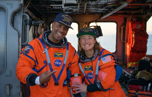 Two Artemis II astronauts, NASA's Victor Glover and Christina Koch, pose together aboard the U.S.S. John P. Murtha after a successful splashdown.