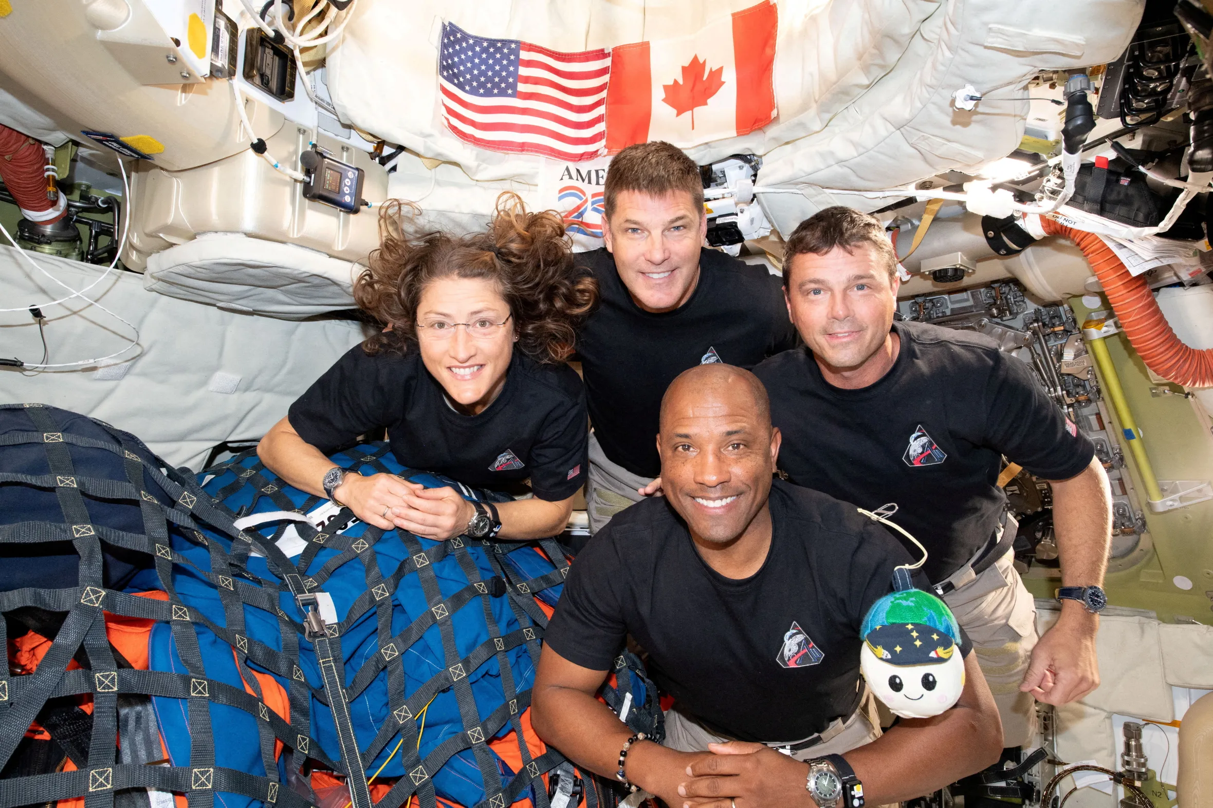 The NASA Artemis II crew, Christina Koch, Jeremy Hansen, Reid Wiseman, and Victor Glover, pose for a group photo inside the Orion spacecraft.
