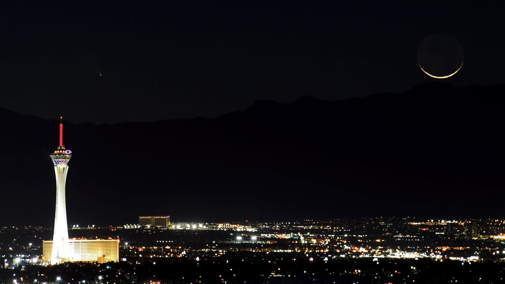 The comet Pan-STARRS and a waxing crescent moon above the Stratosphere Casino Hotel and the Las Vegas skyline at night. Getty Images