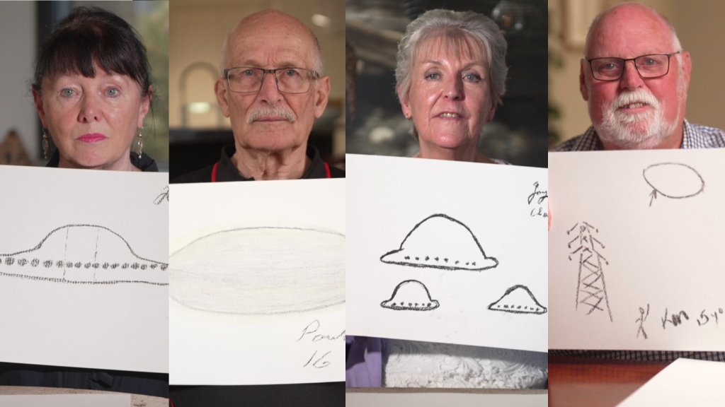 Two women and two men aged in their 60s hold paper drawings of UFOs