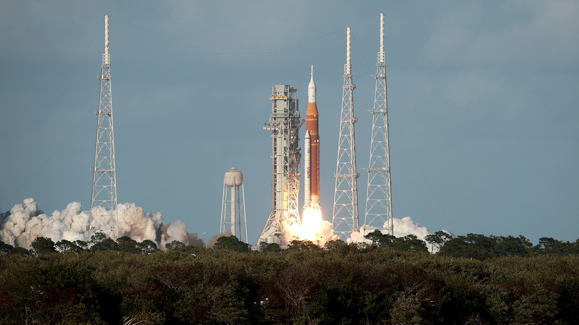 a rocket launches above a plume of fire