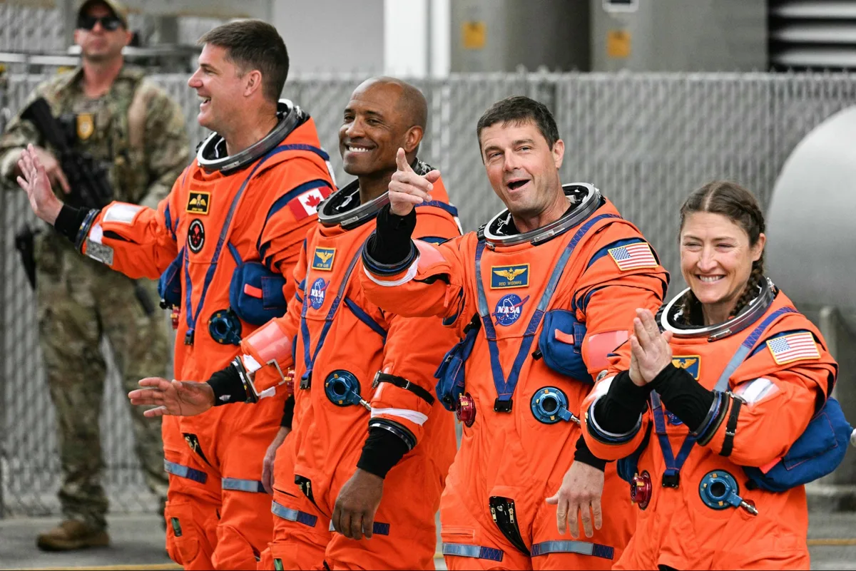 Artemis II astronauts Jeremy Hansen, Victor Glover, Reid Wiseman, Christina Koch wave to crowds before traveling to the launchpad.