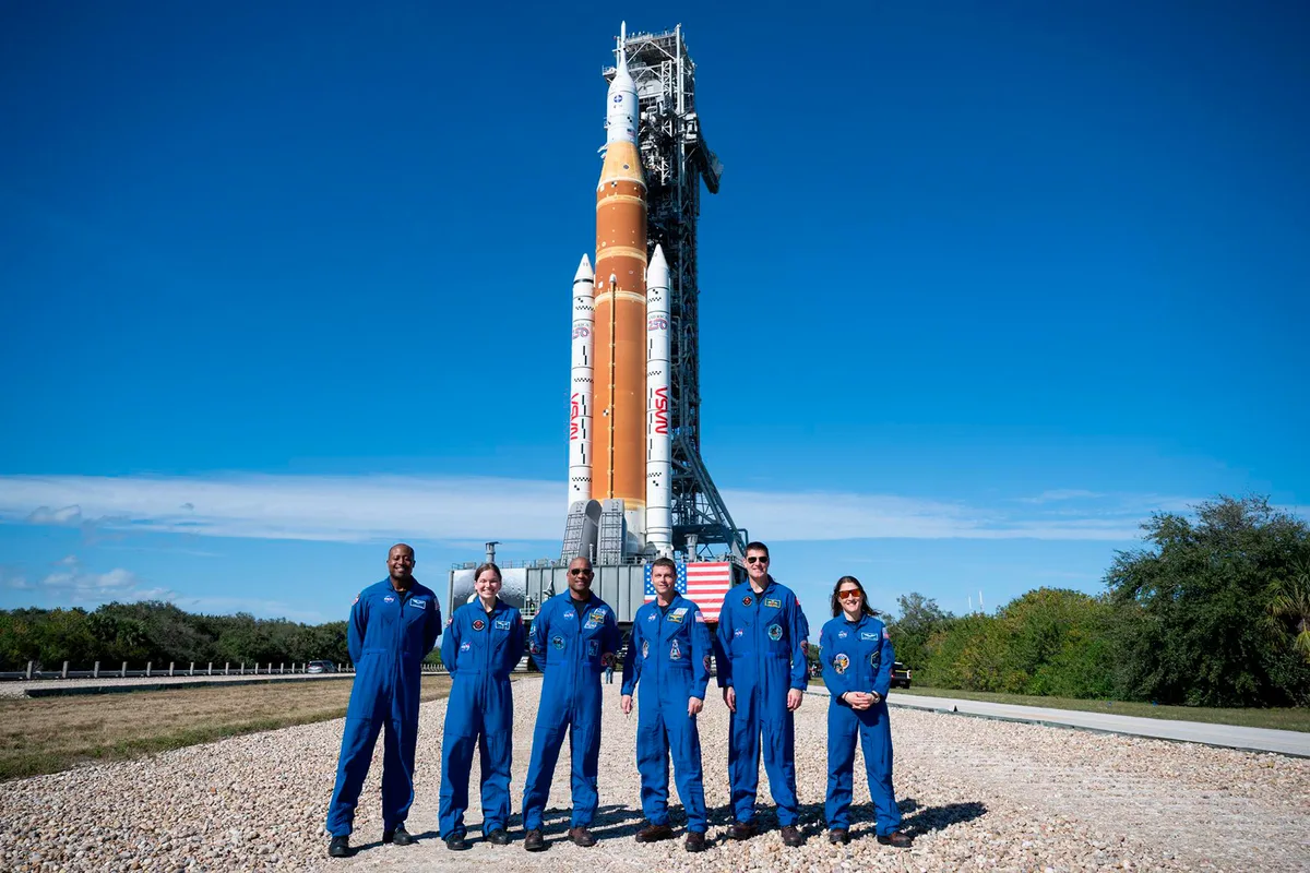 The crew standing in front of the SLS rocket