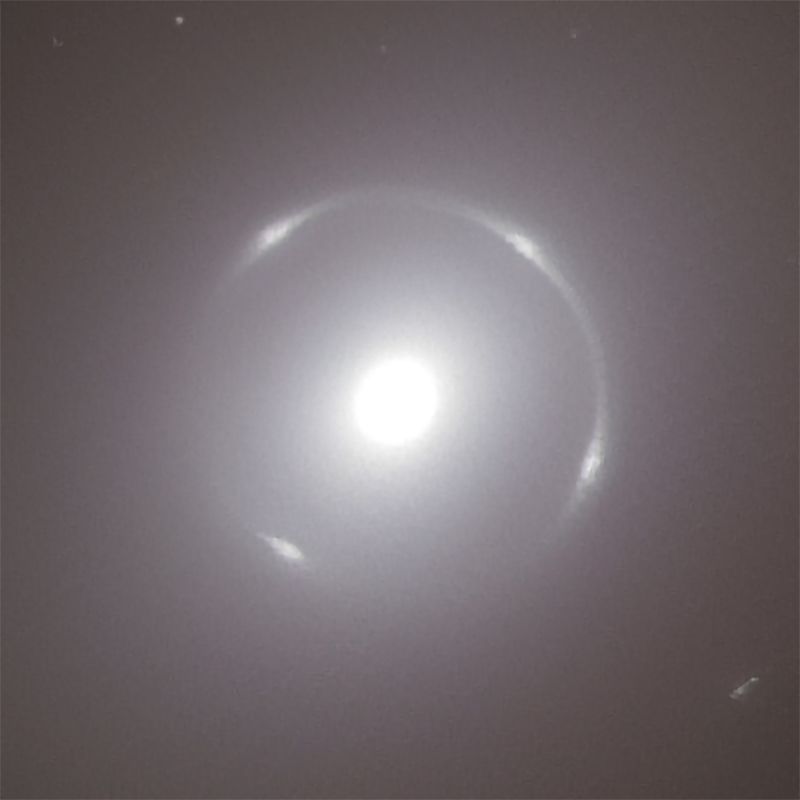 A solid glowing circle with a thin glowing ring around it that has four bright spots along it.