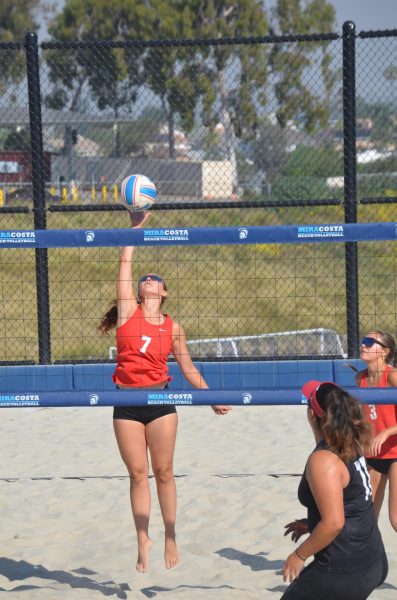 Annie Cummings (#7) hitting the ball over the net during her match against San Diego City on March 27 at MiraCosta. Her duo partner Kiana Merrill (#3) is pictured behind her having just passed her the ball.