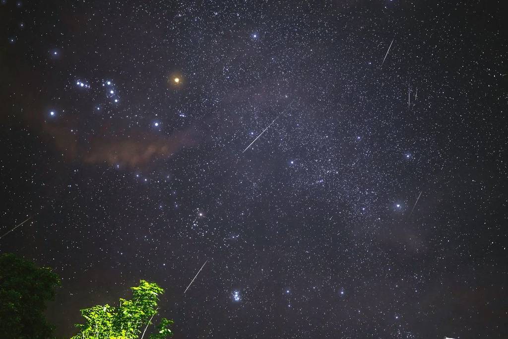 Meteors shooting across a dark starry sky.