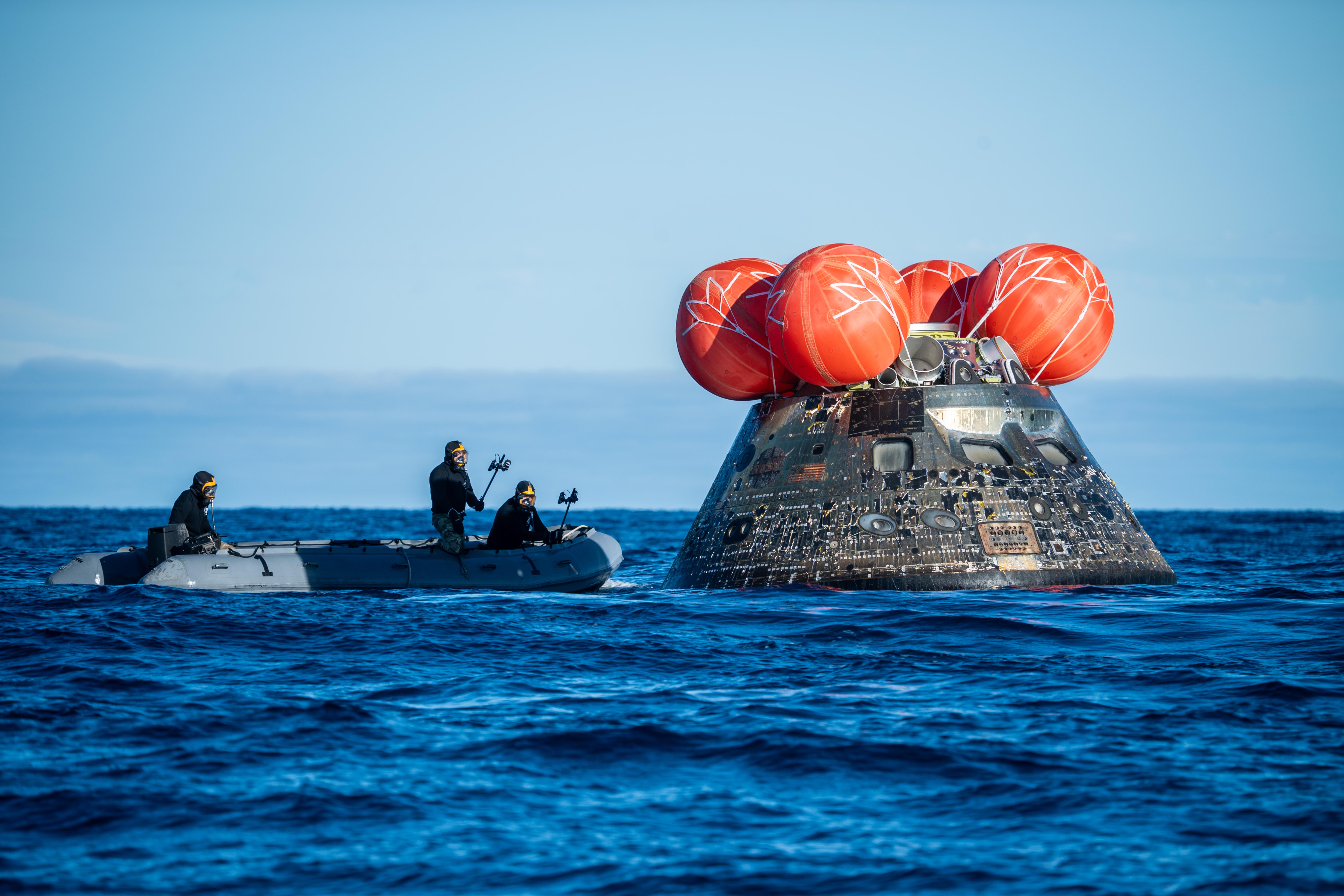 NASA's Landing and Recovery team, along with U.S. Navy personnel...