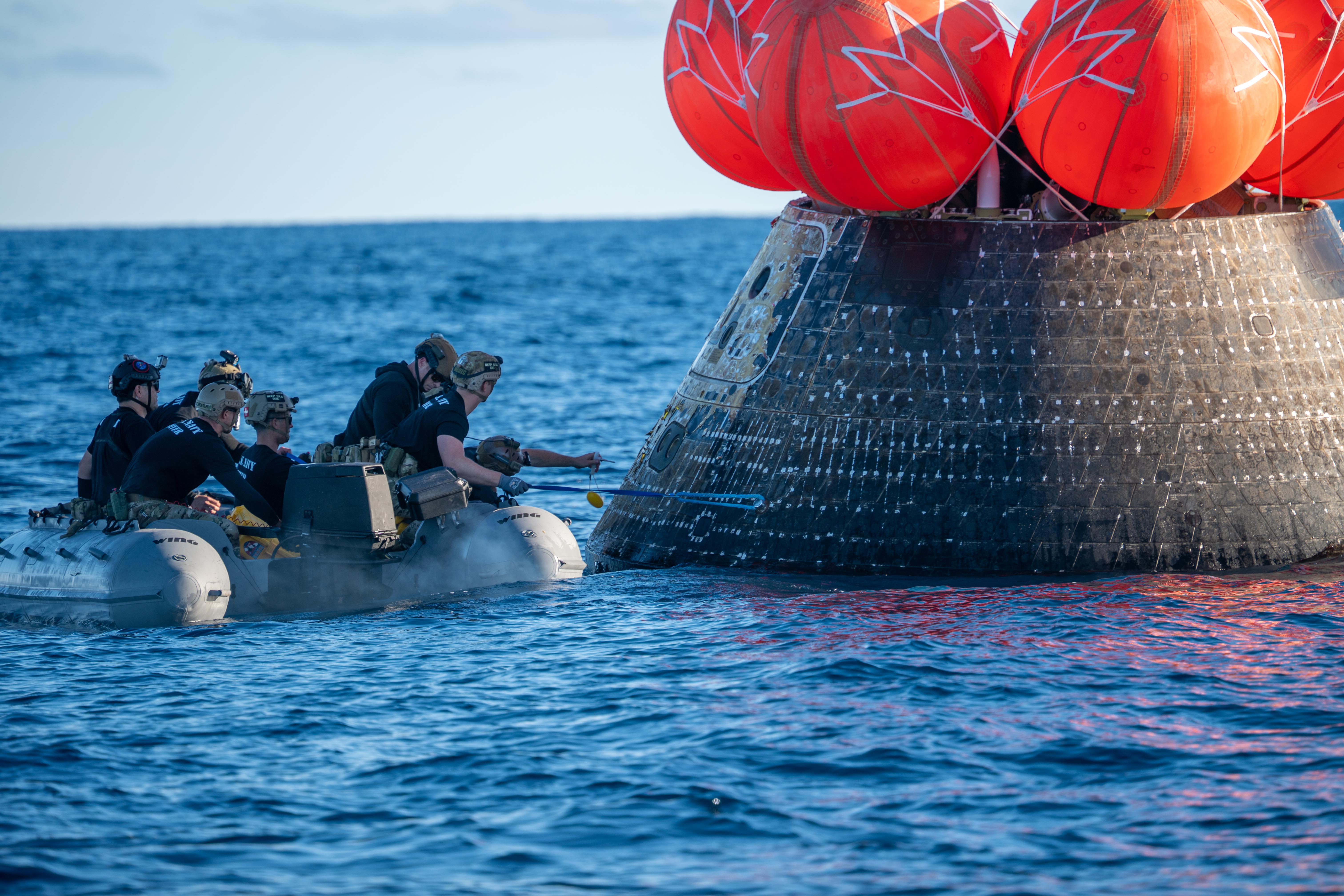 NASA's Landing and Recovery team, along with U.S. Navy personnel...