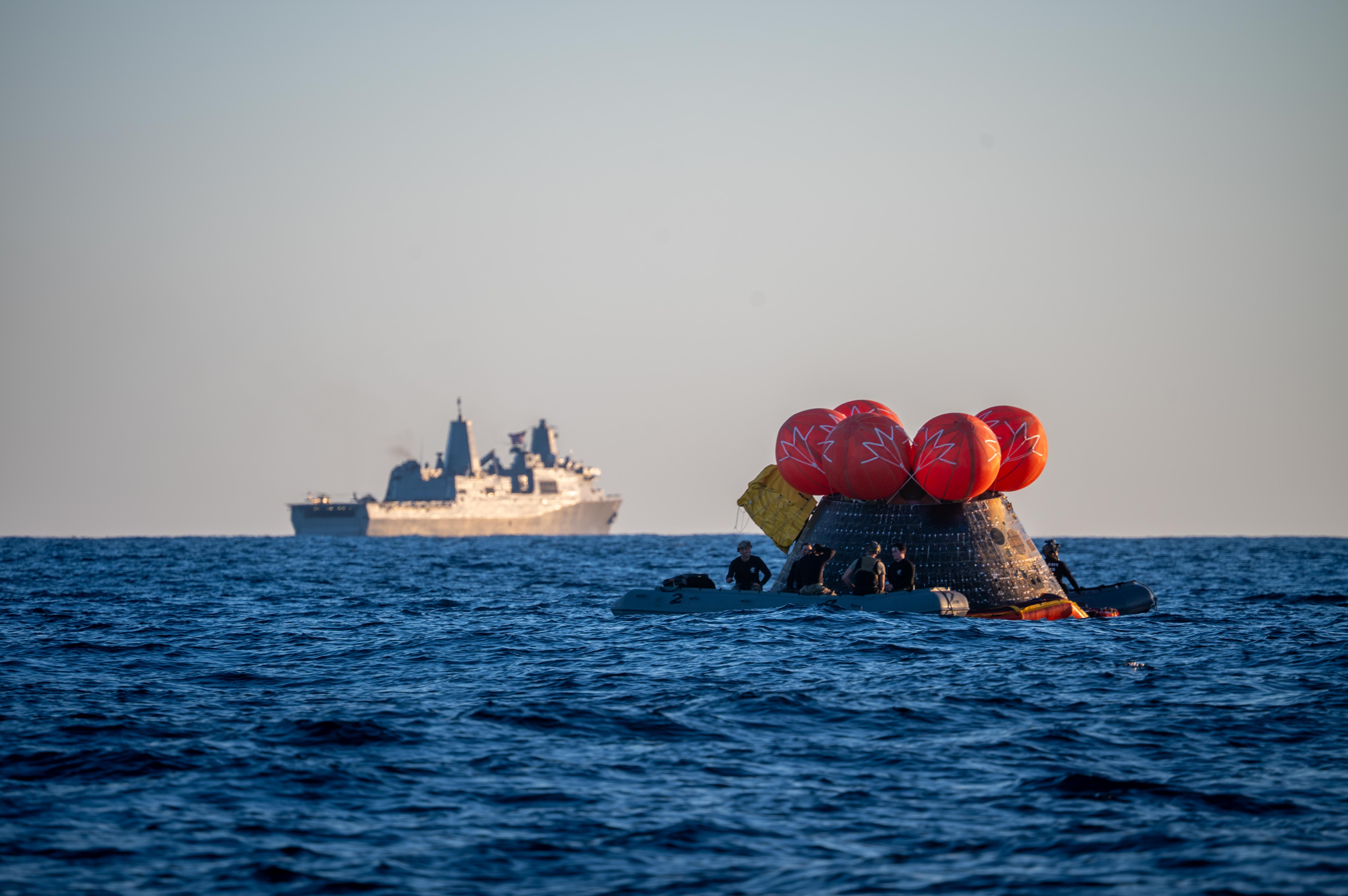 U.S. Navy personnel aboard an inflatable raft, called the front...