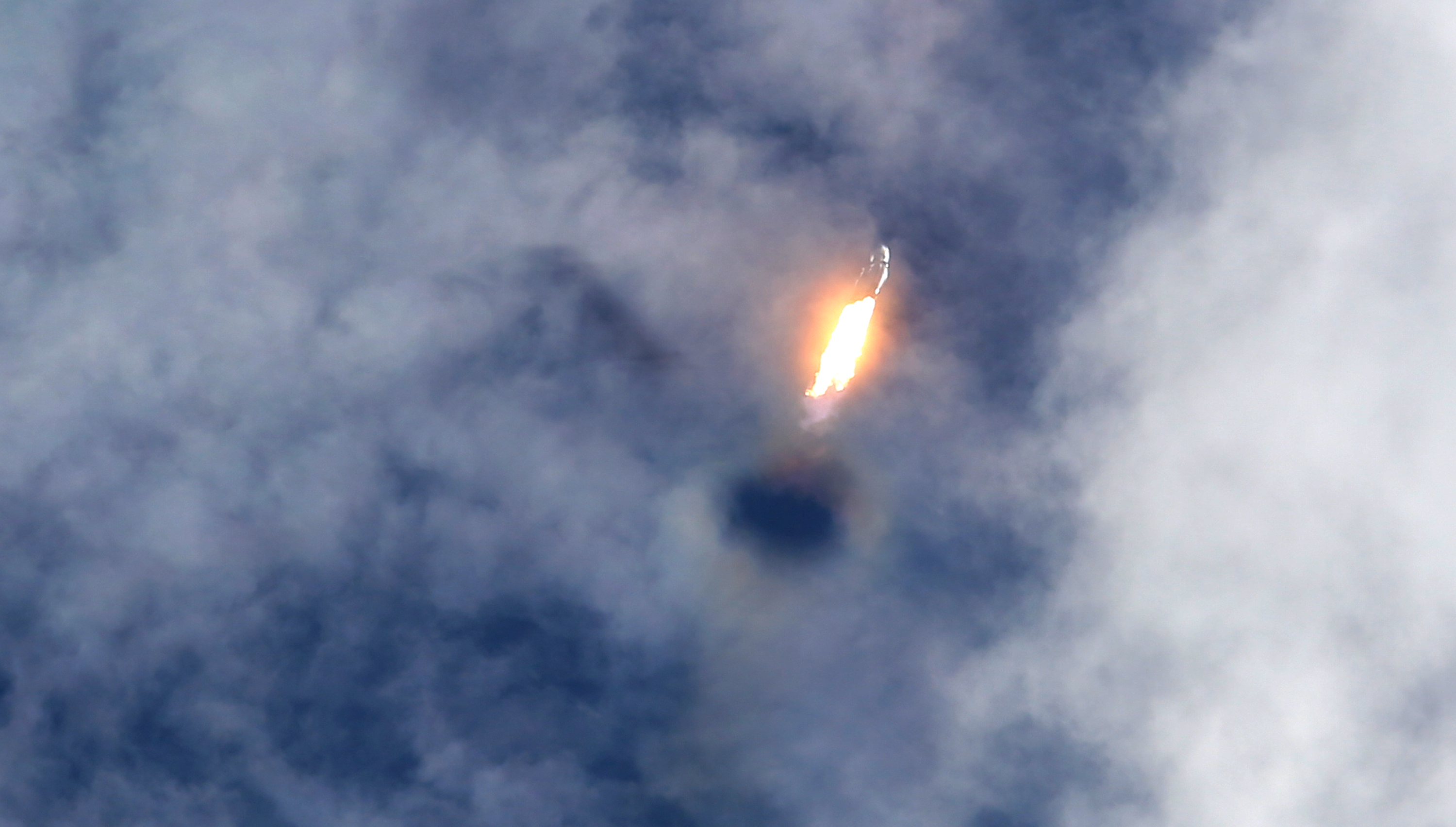 A SpaceX Falcon Heavy rocket punches a hole through the...