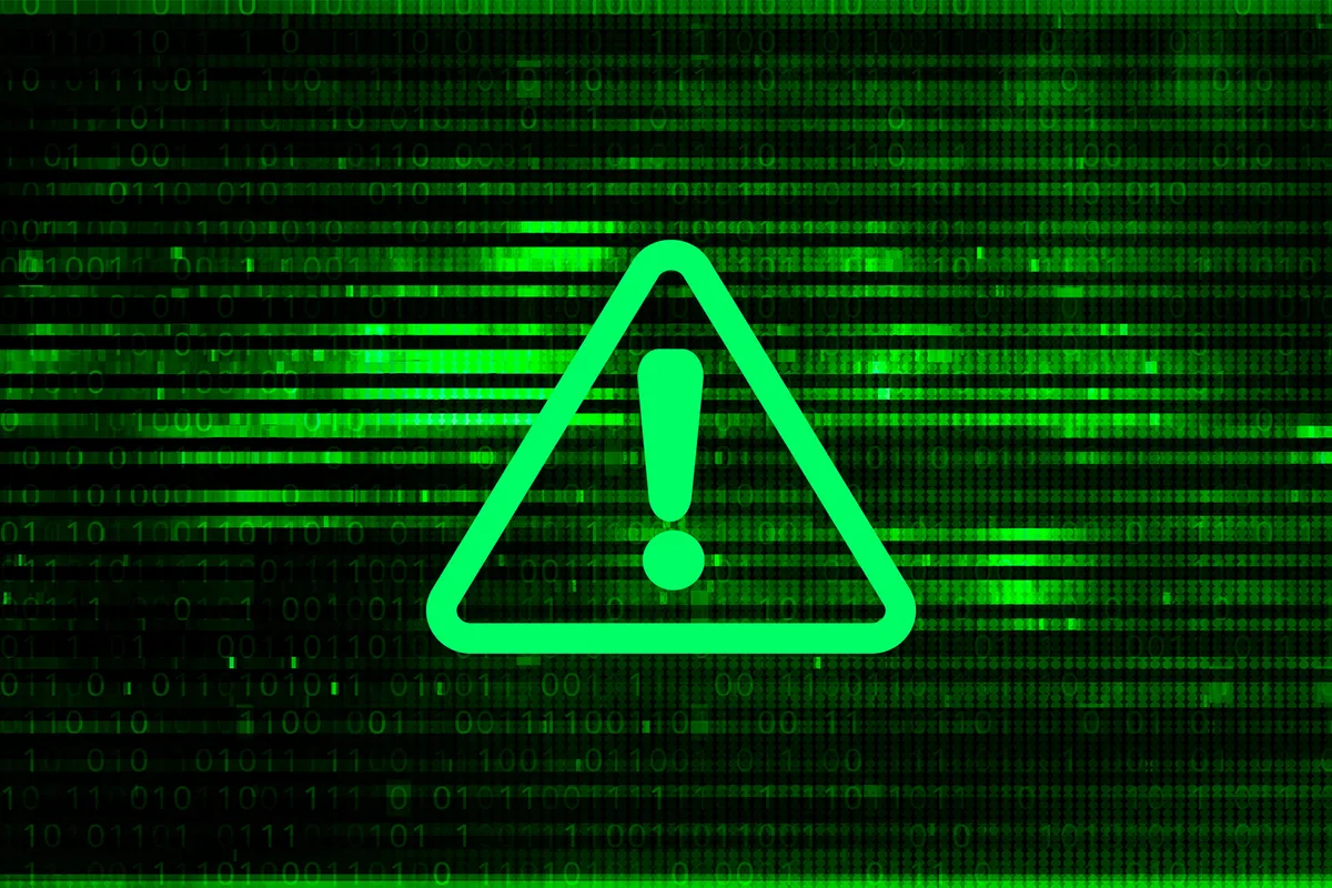 Green computer code with a exclamation mark warning sign