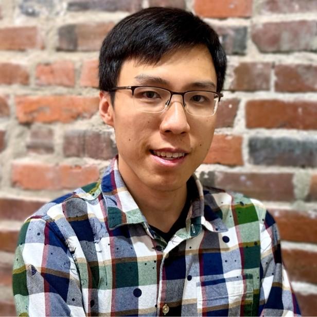 a person sitting in front of a brick wall