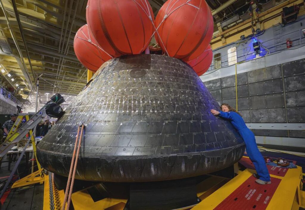 Christina Koch hugs Orion spacecraft
