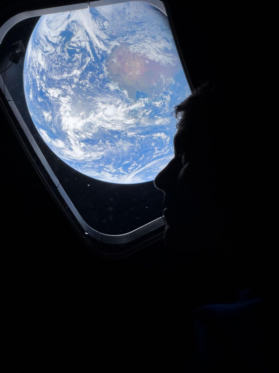 Commander Reid Wiseman looks out over Earth from the window of the Orion capsule
