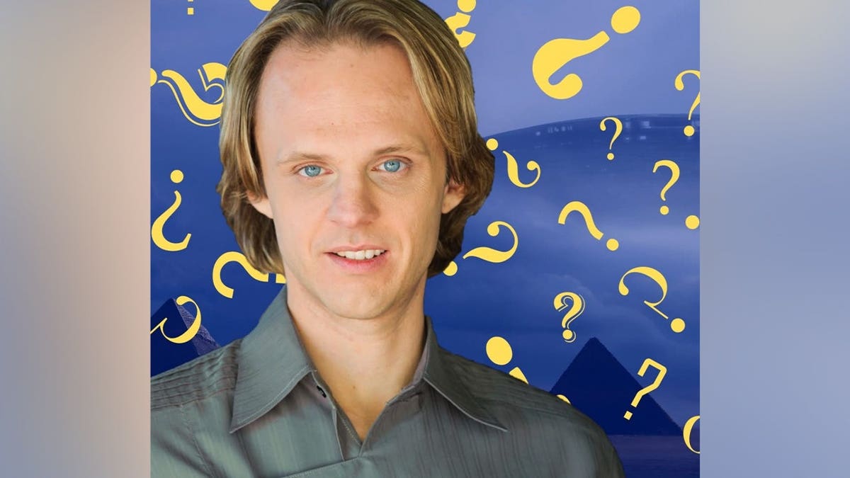 David Wilcock standing and smiling in a casual setting