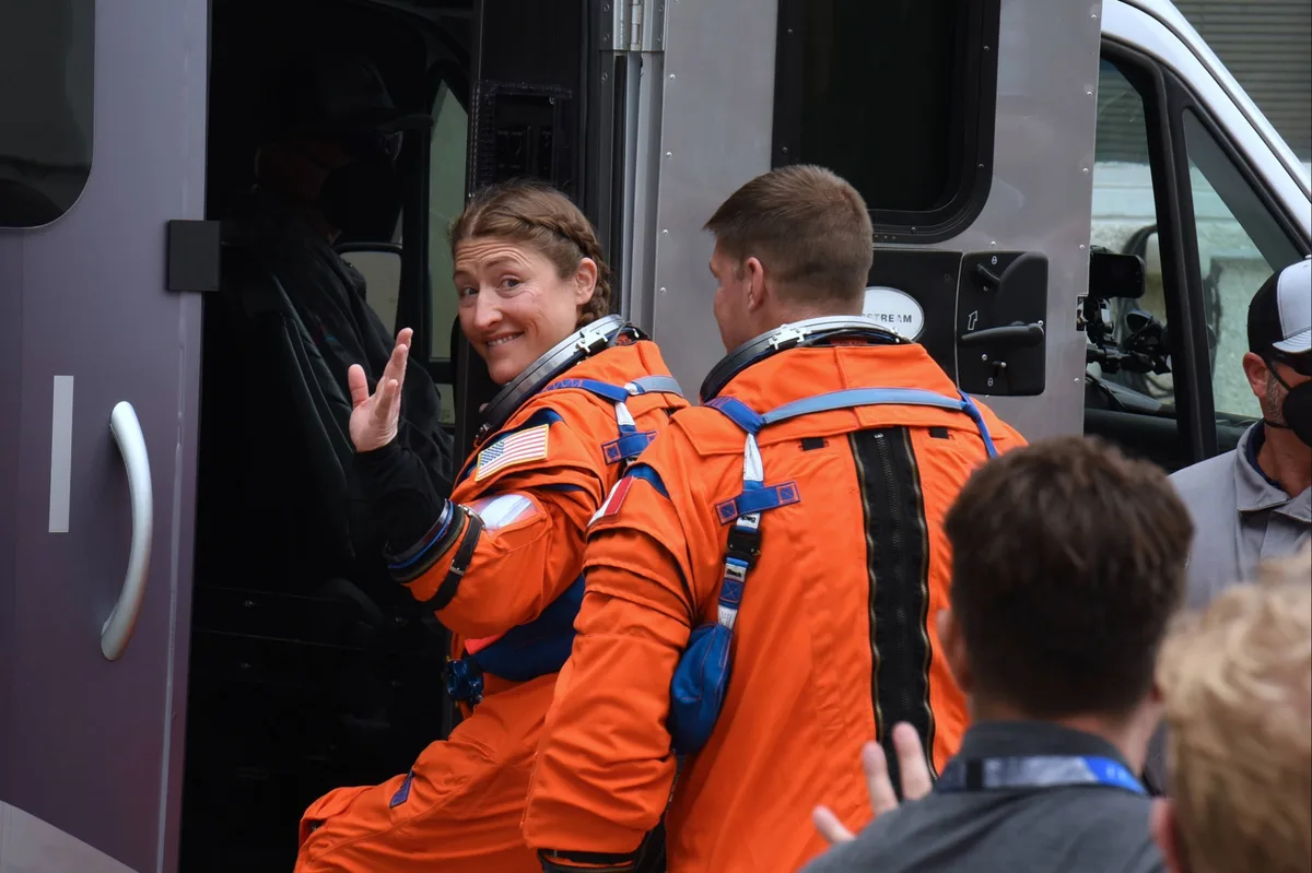 NASA astronaut Christina Koch waves as she and other crew members board the NASA Astrovan.