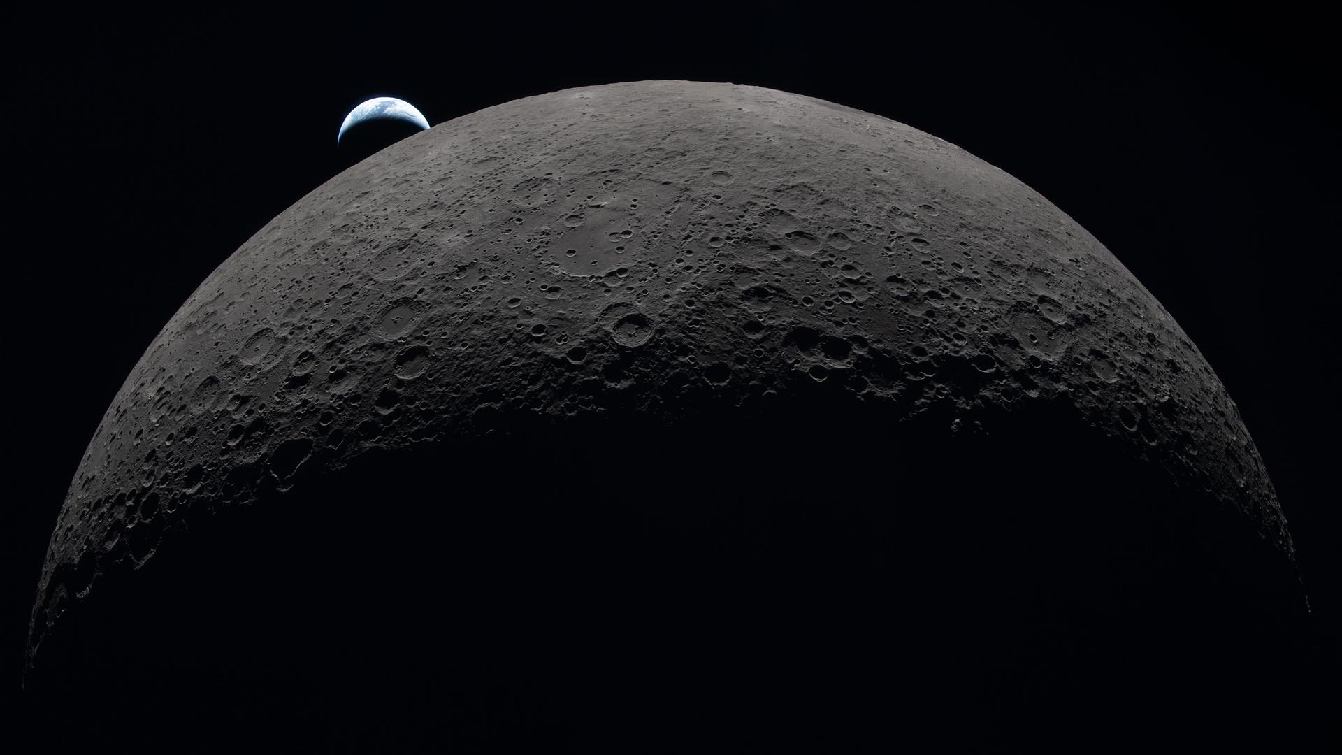 Earth sets at 6:41 p.m. EDT, April 6, 2026, over the Moon’s curved limb in this photo captured by the Artemis 2 crew during their journey around the far side of the Moon. Orientale basin is perched on the edge of the visible lunar surface.