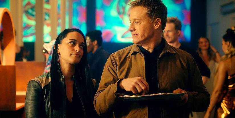 Alan Tudyk as Harry sitting next to Sara Tomko as Asta in Resident Alien