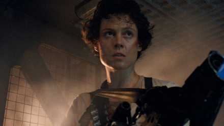 Sigourney Weaver as Ellen Ripley holding a flamethrower in Aliens.