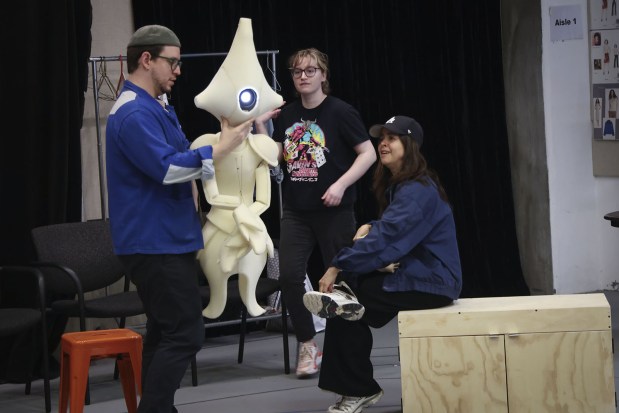 Actor Emma Ramos, right, watches production stage manager Jo Fernandez demonstrate how to operate one of the puppets that will be featured in the Old Globe's world premiere of Amy Berryman's play "Alien Girls." (Sandy Huffaker)